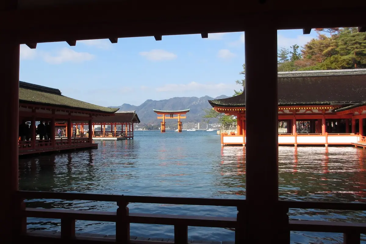 View from inside the shrine's corridors at high tide, with the vermilion torii in the distance across the water